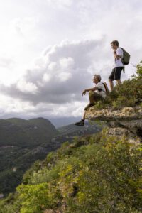 Father and adult son hikers pause on hilltop